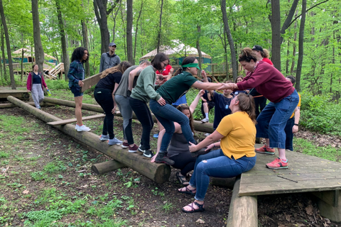 Students outdoors balancing on a beam