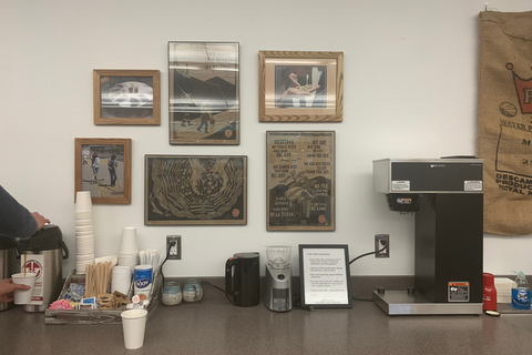 Wall with photos and a table with a coffee maker